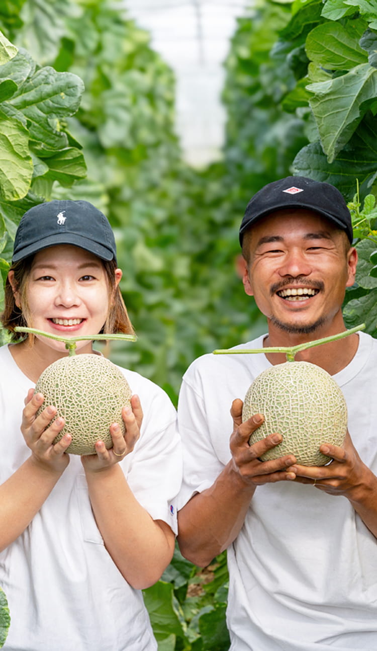 笑顔の生産者がメロンを持っている様子